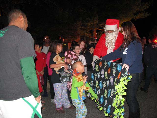 Receiving a new blanket from EMT Ogrin with Santa looking on.