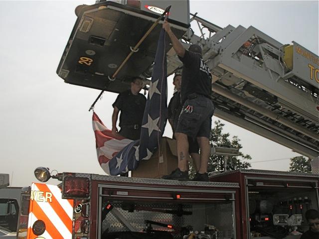 Billy Newberry helps raise the big flag from the bucket of Tower 729